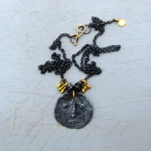 22 karat gold and silver primitive face necklace