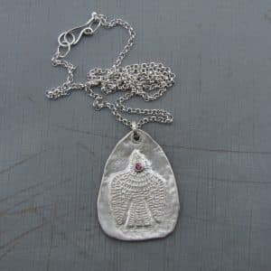 Handmade textured artisan silver necklace with pink eye bird