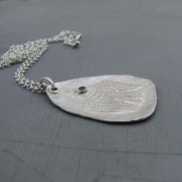 Handmade textured artisan silver necklace with pink eye bird